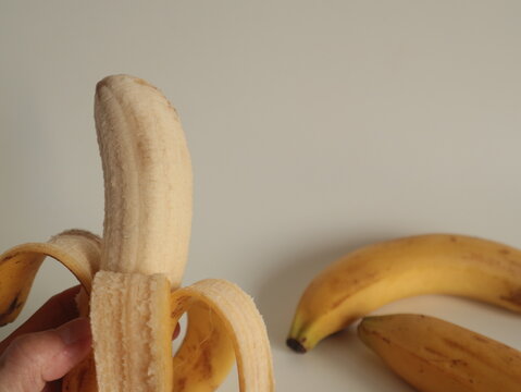 hands peeling a fresh yellow banana