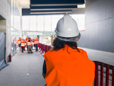 Construction site visitor wearing safety vest and hard hat