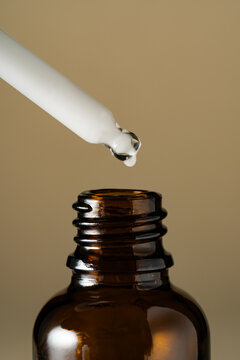Dropper with serum above amber cosmetic bottle
