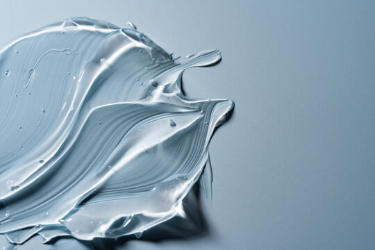 Translucent cosmetic gel smear on pale blue background