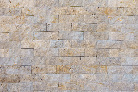 Natural stone brick wall texture background with rustic rectangular blocks