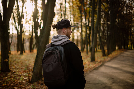 Man with backpack walking through autumn park