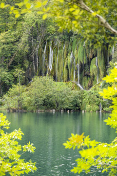 Waterfall and emerald lake in Slovenia forest landscape