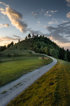 Winding path to hilltop church in Slovenia at sunset