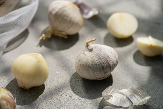 Garlic bulb and clove on a sunlit kitchen surface