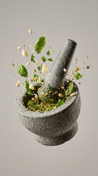 Flying Fresh Ingredients Splashing into Granite Mortar for Homemade Pesto Sauce
