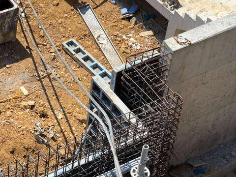 Reinforced concrete foundation construction with exposed rebar cage