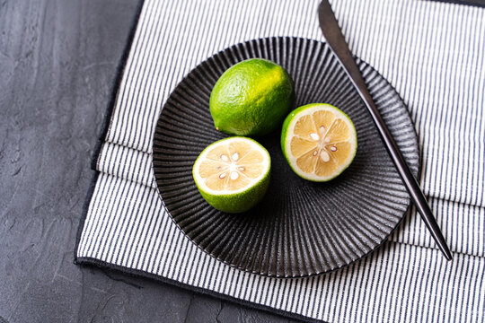 Fresh lime halves on black plate with table setting