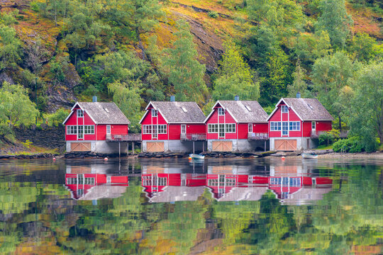 Red boathouse beside a calm Norwegian fjord