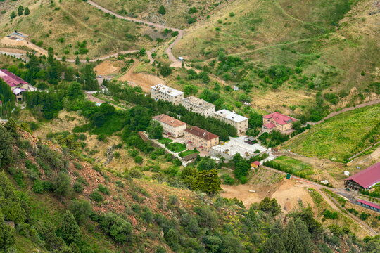 High angle view of Turbaza Yangiabad recreation base among green hills in the former mining town of Yangiabad, Uzbekistan.