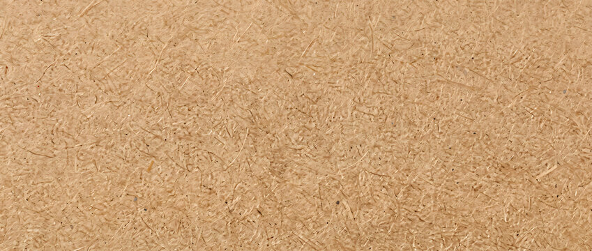 Particleboard texture features densely compressed natural wood fibers and rough tan fragments for rustic backgrounds and material design