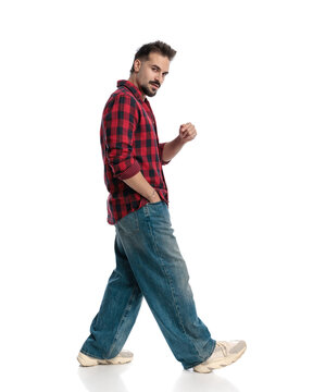 Side view of casual man walking and gesturing