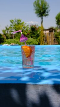 Friends drinking cocktails by the pool. Selective focus.