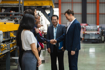 Happy business partner shaking hand in modern factory warehouse meeting, smiling professional team greeting with confidence, Metal Sheet Factory © eakgrungenerd