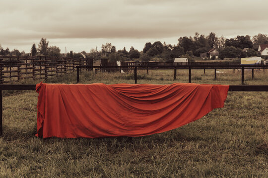 Red cloth on wooden fence in a field in sepia tone