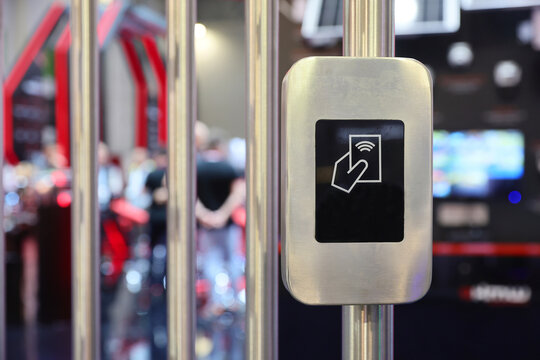 Close-up of a modern contactless RFID card reader on a metallic turnstile for secure access control.