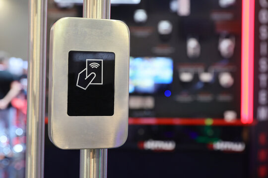 Close-up of a modern contactless RFID card reader on a metallic turnstile for secure access control.