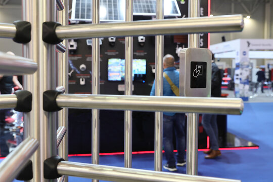 Close-up of a modern contactless RFID card reader on a metallic turnstile,rotating metal door for secure access control.