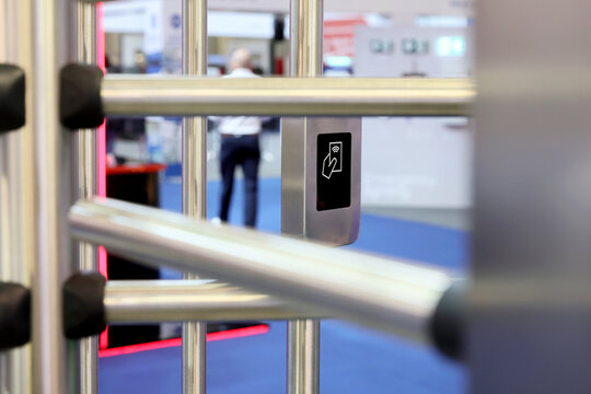 Close-up of a modern contactless RFID card reader on a metallic turnstile,rotating metal door for secure access control.