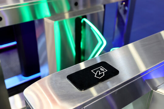 Close-up of a modern contactless RFID card reader on a metallic turnstile for secure access control.