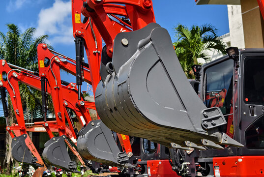 Compact hydraulic excavators parked outdoors with buckets lowered and metal tracks