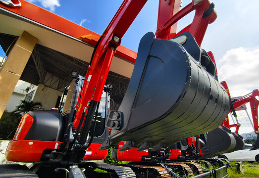 Compact hydraulic excavators parked outdoors with buckets lowered and metal tracks