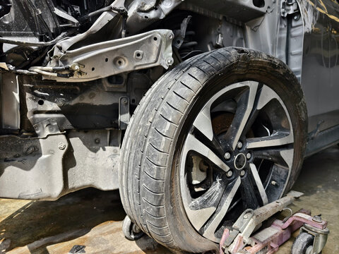 Damaged car tire with a torn tread and visible wheel rim