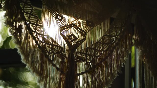 Macrame wall hanging decor near window during sunny day