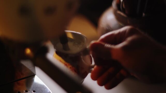 Barista steaming milk in a small ceramic pitcher using an espresso machine during daytime