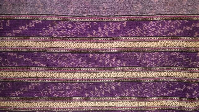 Close up of traditional purple woven fabric with intricate patterns
