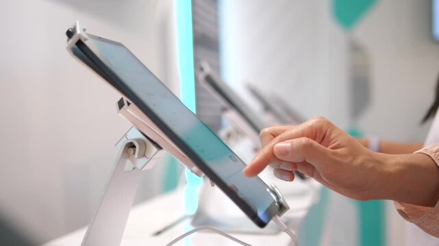 Close up of hands using digital tablets on display stands