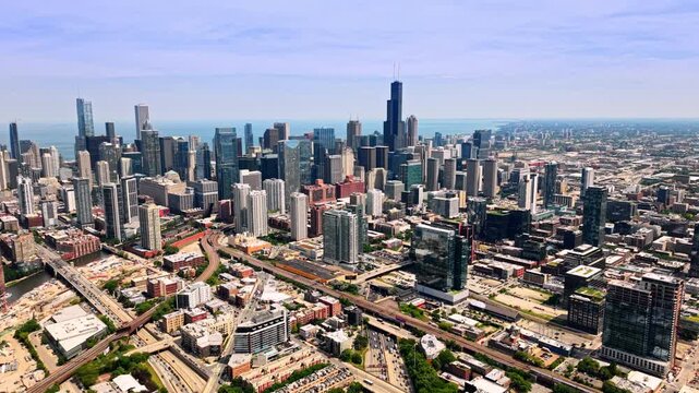 Urban sprawl and highway overpass in downtown Chicago. Dense metropolitan architecture, high-rise buildings, multi-lane roads, railways and distant lake horizon.