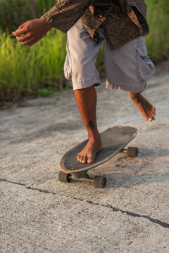 Detail skateboarding on a Path With Bare Feet in a Green Area