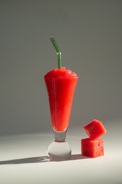 Red watermelon smoothie drink in modern glass with green glass