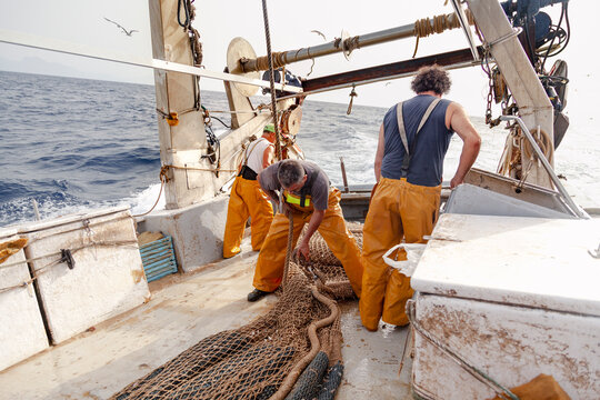Fishing crew preparing nets during offshore work