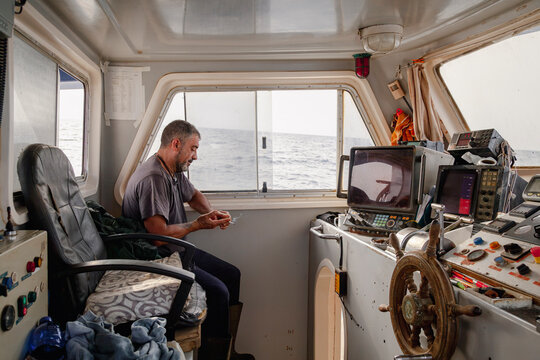 Fisherman resting inside commercial fishing boat wheelhouse