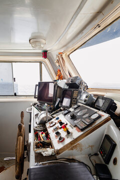 Empty wheelhouse with navigation controls aboard a fishing boat
