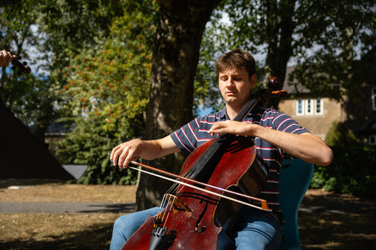 Playing cello outdoors in sunlight