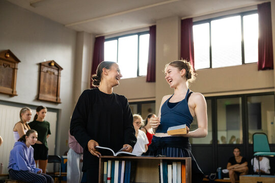 Performers giggling over a prop book