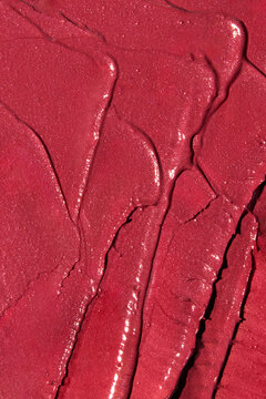 Bright red lipstick texture smeared with waves and imperfections