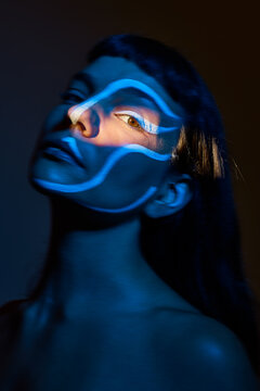 Figure with blue shadow on face in artistic light setup