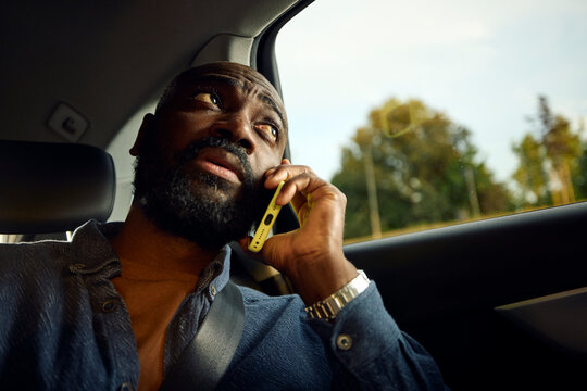 Man speaks on a mobile phone while in a car