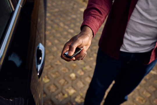 Anonymous man locks his car using a remote key