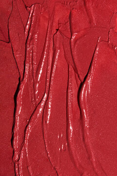 Bright red lipstick texture smeared with waves and imperfections