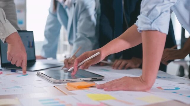 Business team takes notes, reviews documents, and analyzes financial data meeting in office.