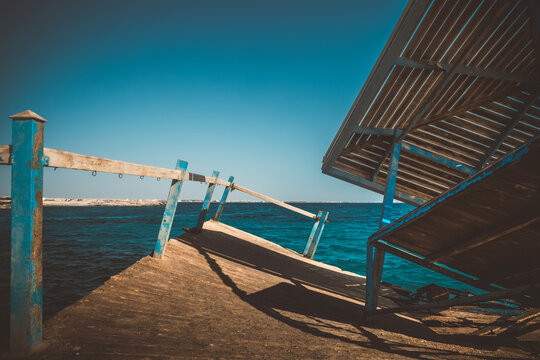 Scenic view of broken and collapsed wooden pier by turquoise sea
