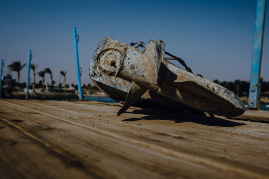 Close up view of damaged and corroded boat propeller covered in sand