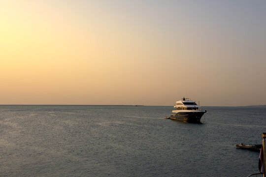 Scenic view of a luxury motor cruise yacht at sunset in the open sea