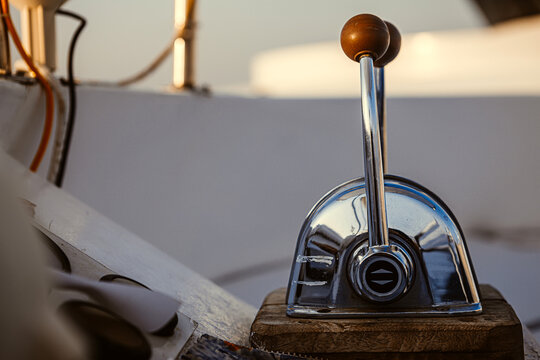 Close up of dual lever marine throttle control on a yacht deck at sunset