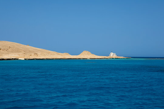 Scenic coral reef in turquoise ocean water near desert coastline